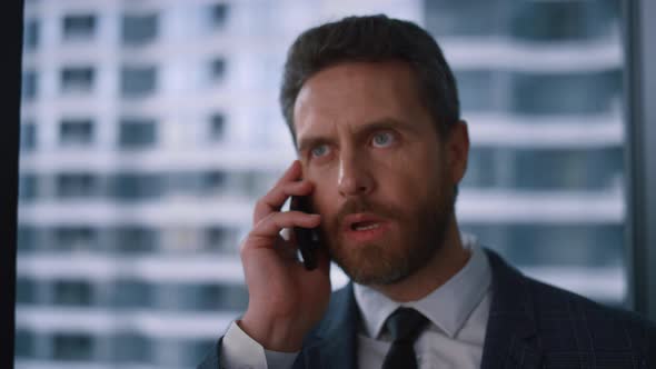 Focused Entrepreneur Making Call Using Mobile Phone in Modern Financial Office alt