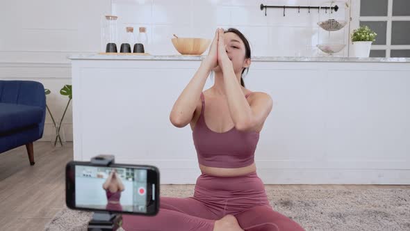 Asian woman teaching yoga exercise on live streaming