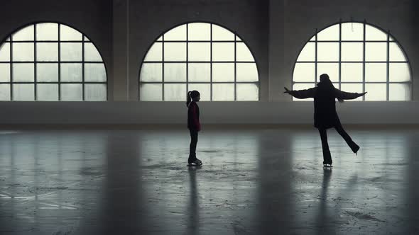 Woman Coach Shows Her Girl Student Elements of Figure Skating Choreography alt