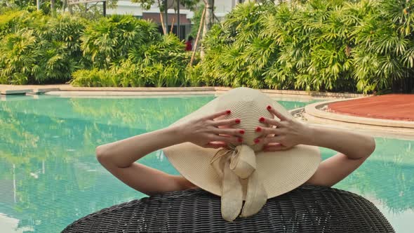 Woman in Straw Hat Resting by Pool alt