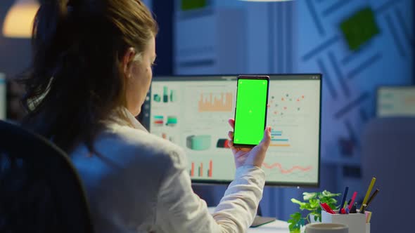 Back View of Business Woman Looking at Smartphone with Green Screen alt