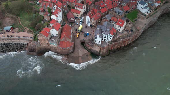 Quaint Robin's hood bay Yorkshire scenic tourist town aerial coastline view reverse tilt up alt