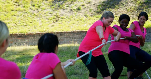 Group of women playing tug of war during obstacle course alt