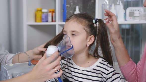 Portrait of a Woman Pediatrician and a Little Girl with an Inhalation Mask From a Nebulizer in the