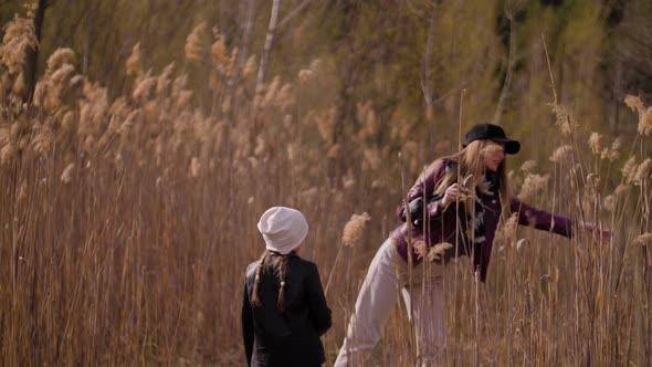 Happy Family Mother and Daughter Harvest Reed in Spring Time. alt
