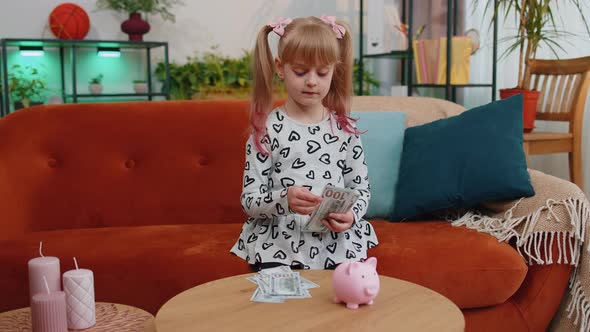 Little Toddler Kid Girl Counting Money Dollar Banknotes for Future Needs at Home Desk with Piggybank alt