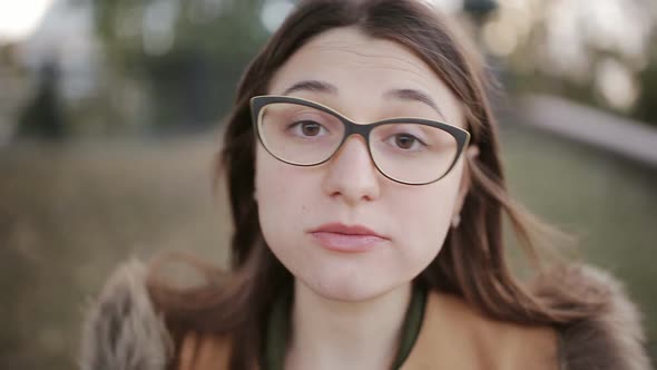 Girl with Glasses Bites a Big Slice of Pizza Directly Into the Camera Closeup