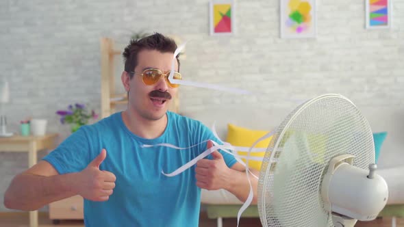Funny Young Man in Front of a Working Electric Fan Escapes From the Heat in the Apartment Slow Mo alt