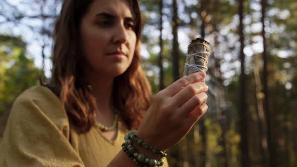 Woman or Witch Performing Magic Ritual in Forest alt