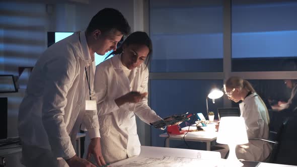 Technology Research Laboratory: Mixed Race Electronics Engineers in White Coats Working with alt