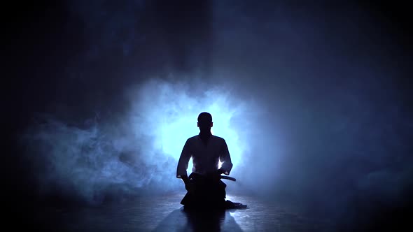 Aikido Master Wearing Traditional Samurai Hakama Clothes Takes His Japanese Sword Out of Scabbard alt