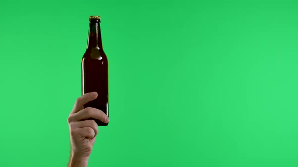 The Male Hand Points with the Index Finger to the Other Hand Holding a Bottle of Beer or Lemonade alt