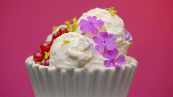 Bowl with tasty vanilla ice cream decorated with edible flowers 