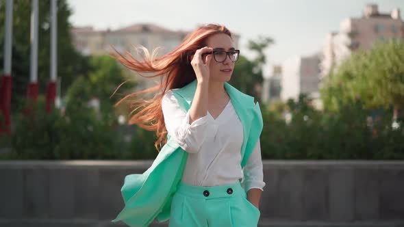 Beautiful sexy woman with long red hair in glasses is dancing on go happiness alt