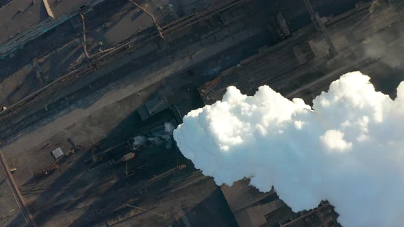 Industrial Zone with a Large Red and White Pipe Thick White Smoke Is Poured From the Factory Pipe in alt