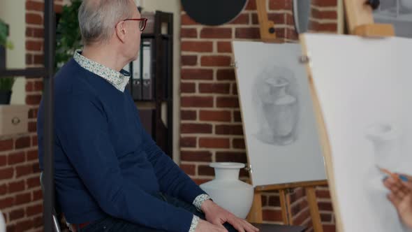 Senior Artist Showing Vase Model to People Attending Workshop Practice alt