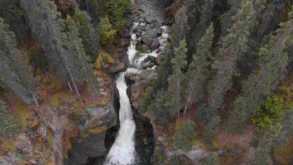 Waterfall Cascading Over Rocky Mountain Slope In Temperate Rainforest At Alaska, USA. - Aerial Tilt- alt