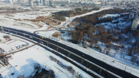 Flight over the city block. Winter cityscape. The city highway is visible. alt