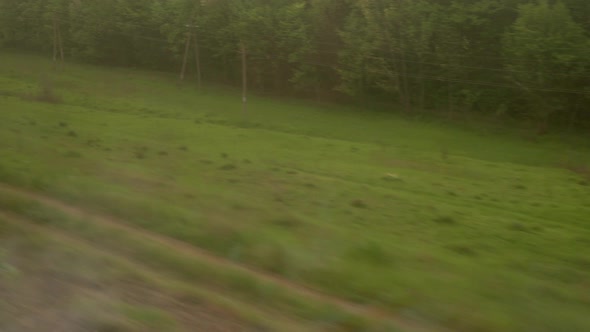 View From Window of Highspeed Train on Landscape of Beautiful Nature Field Road with Car and Forest