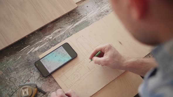 Carpenter Uses Mobile Phone for Drawing Details
