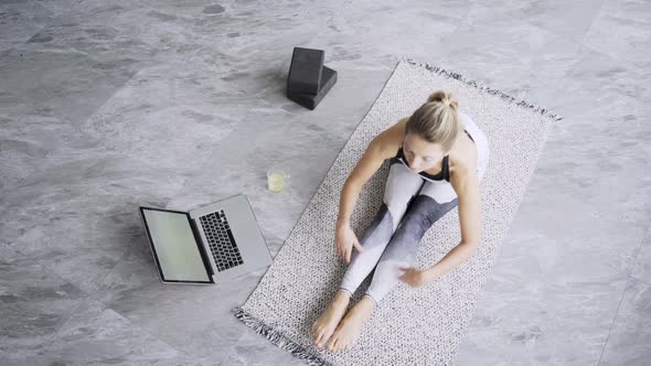 Professional Yoga Trainer in Sportswear Stretches Back