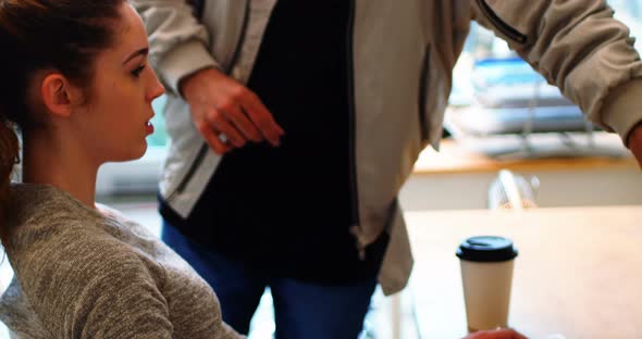 Executives interacting while working at desk alt