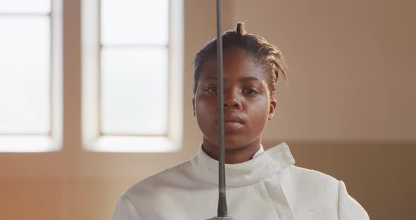 Female fencer athlete during a fencing training in a gym alt
