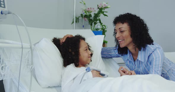 Front view of African american mother talking with her son in ward at hospital 4k alt