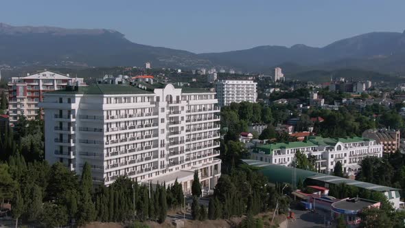 The Famous Riviera Sunrise Hotel in Alushta is Among Other Buildings of the City and Beautiful Green alt