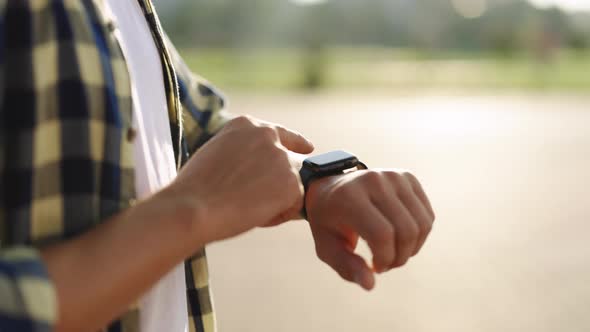 Close Up Shot of Male's Hand Uses Touching of Wearable Smartwatch at Outdoor