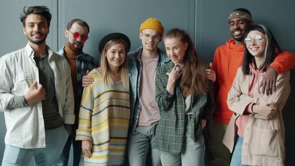 Slow Motion Portrait of Successful Business Team Standing Indoors Against Gray Color Background alt