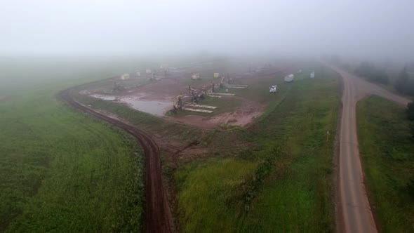 Aerial Flying on Oil Pumps at Oilfield Cluster in a Foggy Field After Rain