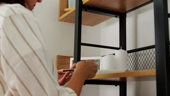 Woman with Matchsticks Lighting Candles at Home alt