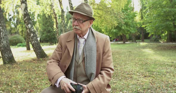 Elegant Old Man Looking for Park View and Taking Pictures on Camera alt