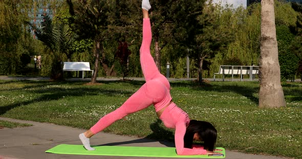 Attractive fit black woman stretching in park, female fitness yoga routine.