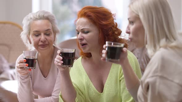 Three Charming Attractive Slim Women Drinking Soda Water Talking Sitting Indoors alt