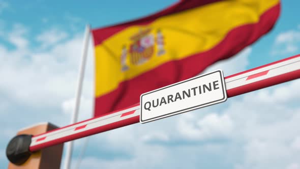 Barrier Gate with QUARANTINE Sign Being Open Near Flag of Spain alt