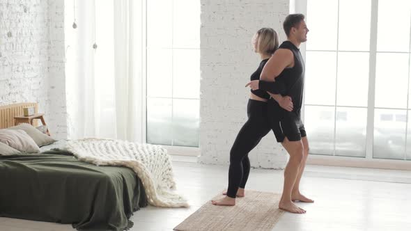 Fitness Couple Man and Woman Are Doing Squats Exercises Together at Home