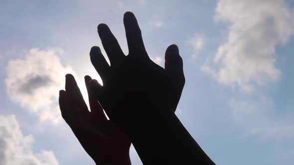 Close up of man hands playing  hand with the sun light on the blue sky background.