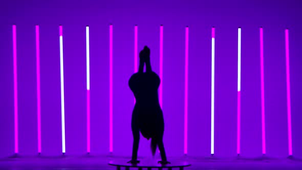 A Woman Standing on Her Hands Does a Split Stretches Her Legs Up Bends Them Sits in a Fold Pose alt