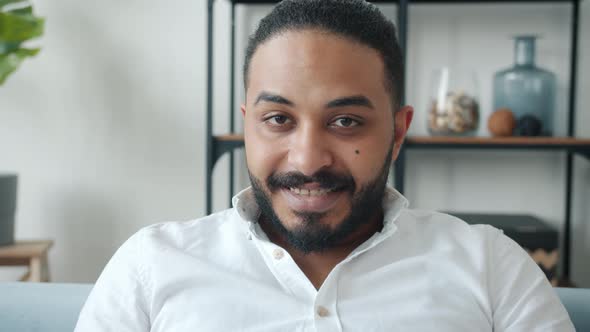 Portrait of Attractive Middle Eastern Guy Smiling and Looking at Camera Indoors in Apartment alt