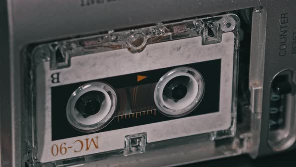 Audio Cassette in the Tape Recorder Playing and Rotates alt