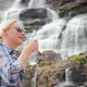 Young Woman Drinks Clear Water From a Waterfall in Norway - VideoHive Item for Sale