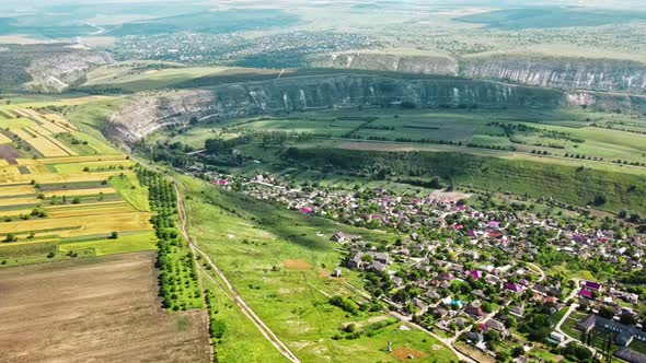 Aerial drone view of nature, valley with river and village, hills and fields, greenery, Moldova alt
