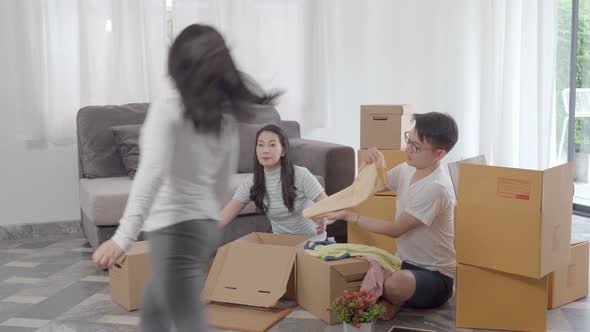 happy Asian family moving to new house with cardboard boxes and arrange the house.