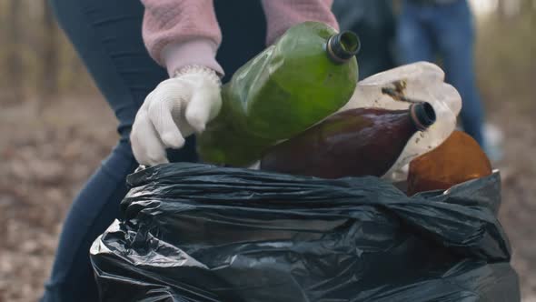 Woman Putting Household Waste Into Bin Bag alt