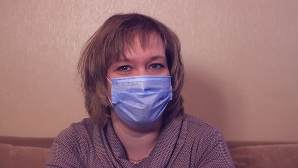 Happy Woman in a Medical Mask is Looking at the Camera and Talking alt