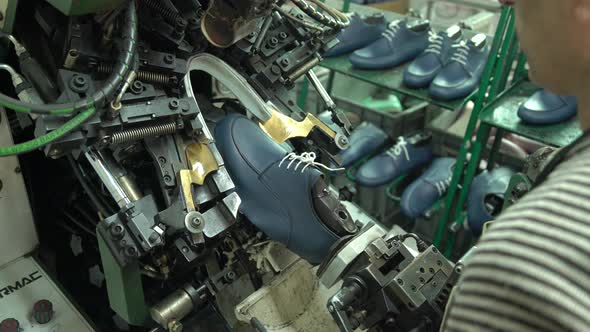 Shoe Manufacturing Factory Worker Working On Autonatic Machine