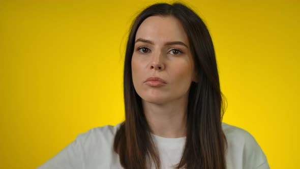 Thoughtful Young Woman Looks at the Camera and Thinks Deeply About Something alt