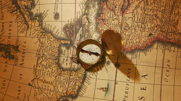 Old vintage compass lying on the ancient map. Used in sailing for navigation. alt